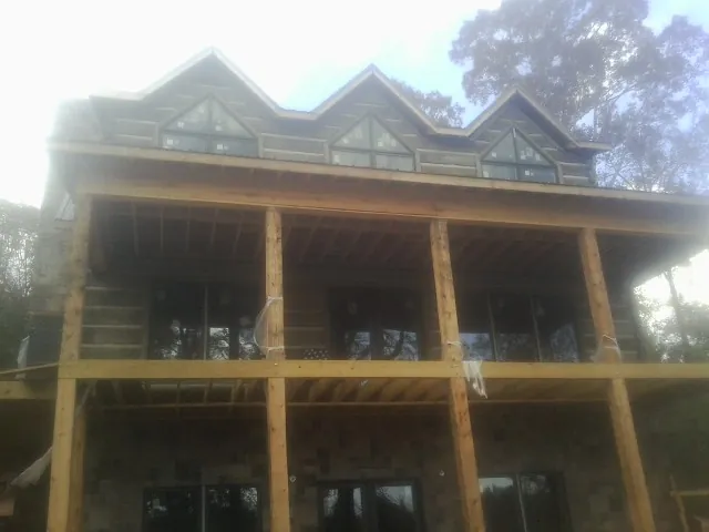 Dormers and porch framing on a large log home under construction — Roof Coating work by our crew in Westerville