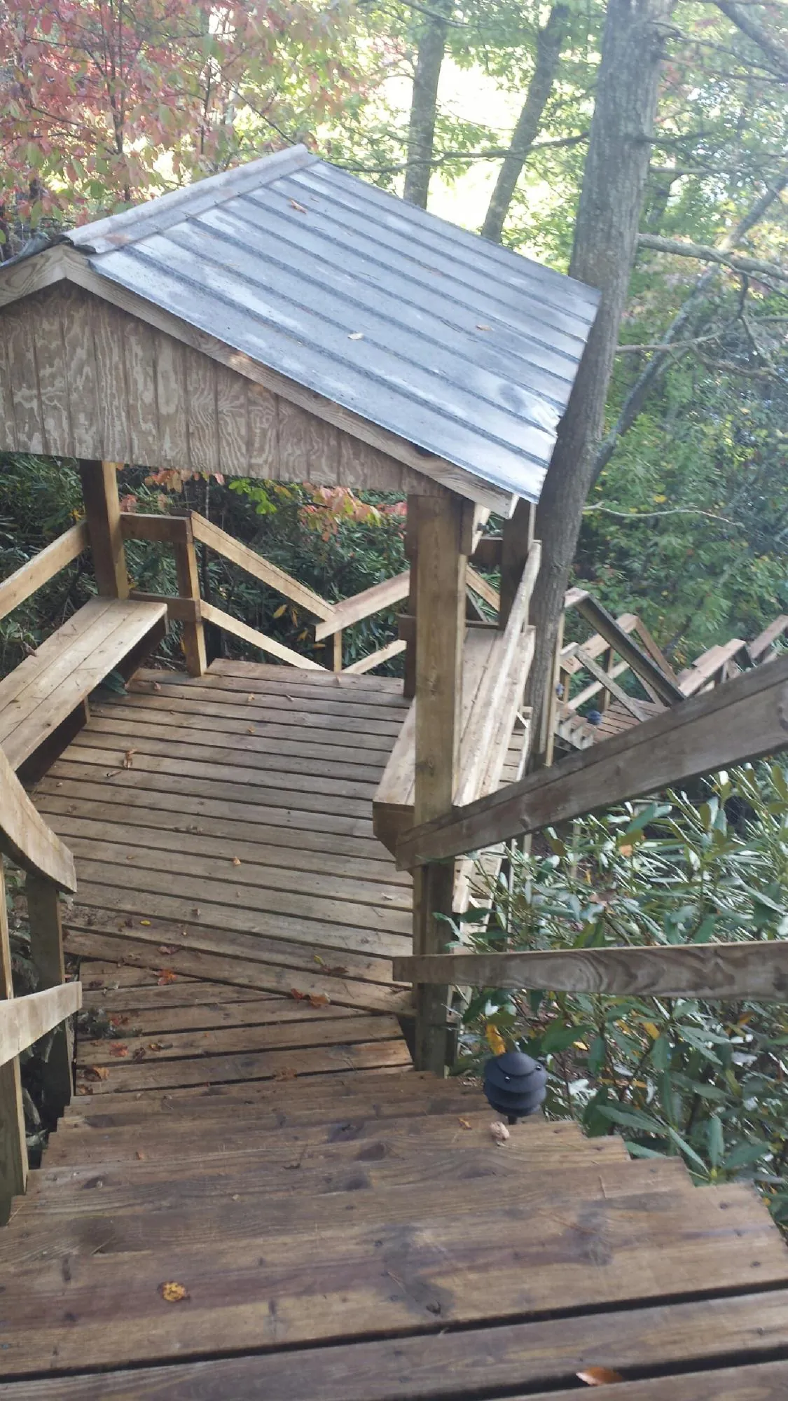 Metal roofed shelter over wooden steps on a wooded walkway — Skylight Repair & Installation work by our crew in Westerville