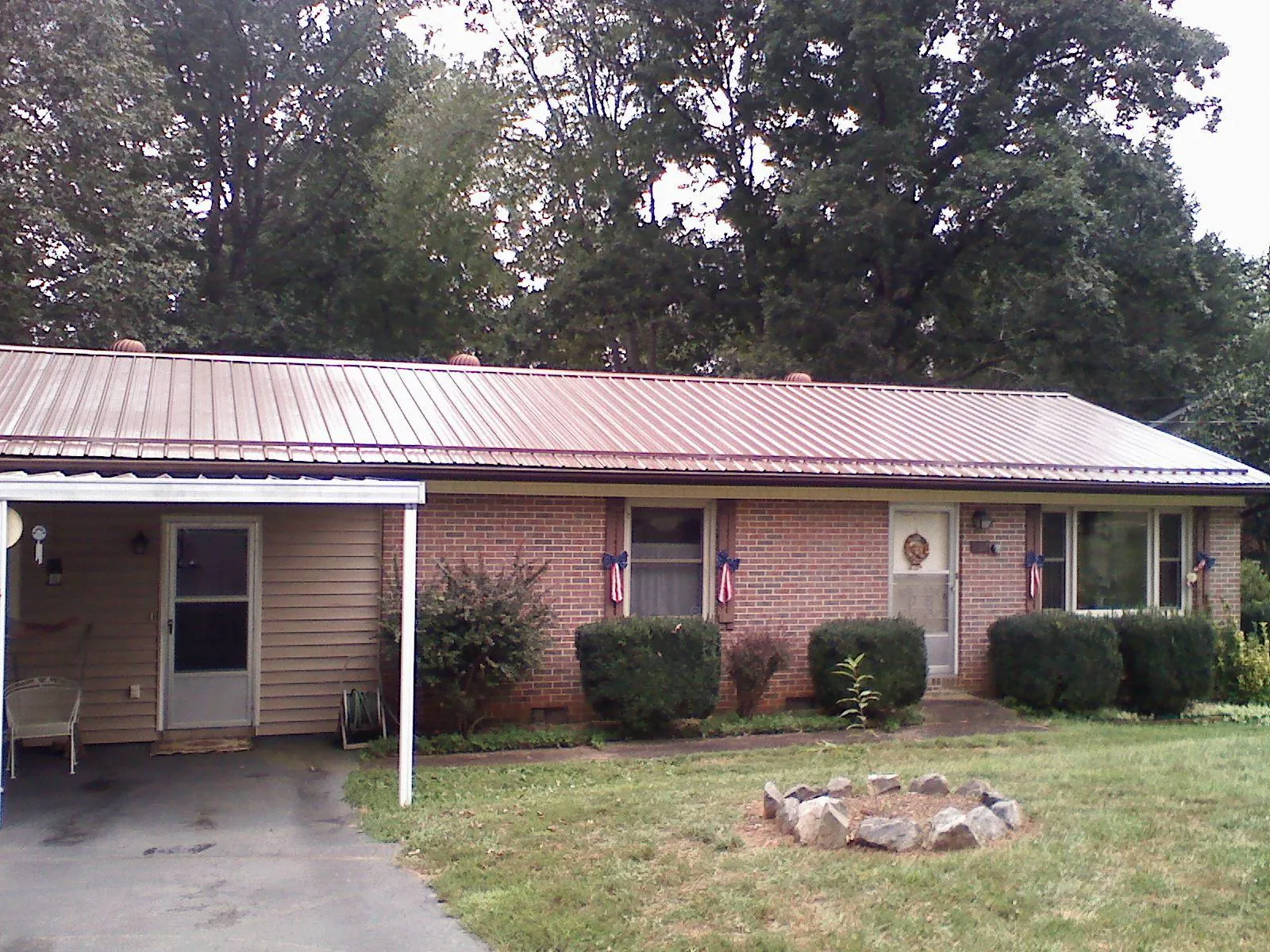 Bronze metal roof and carport on a brick ranch home — Roof Repair work by our crew in Westerville